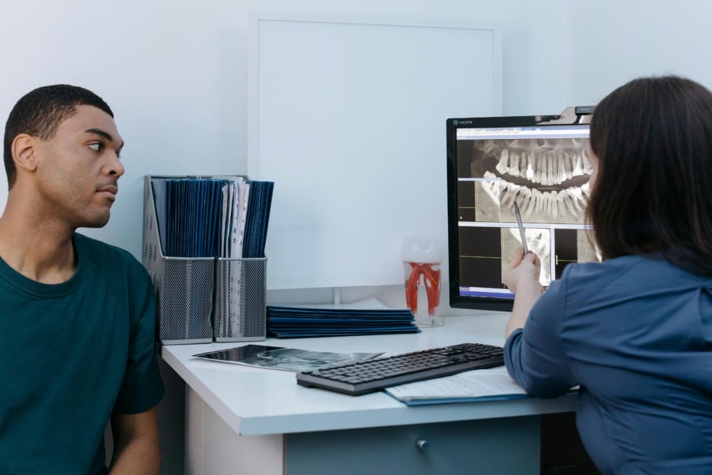 man listening to dentist